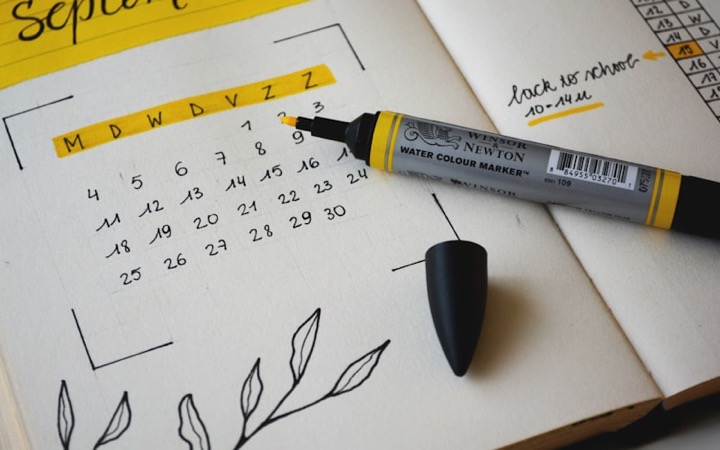 Open planner journal with calendar pages and marker