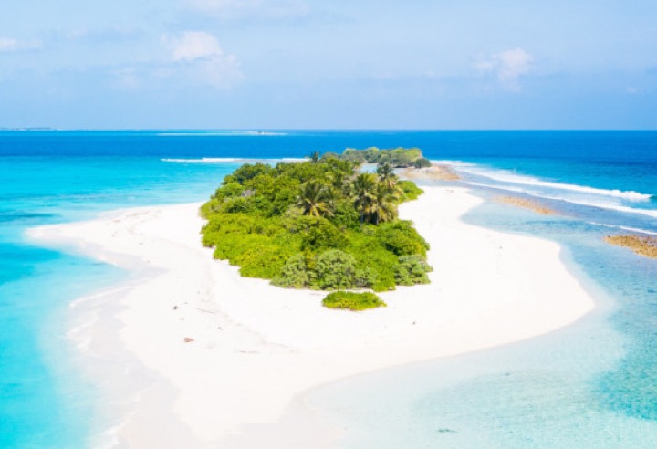 Aerial view of a tropical Maldivian island with turquoise lagoon